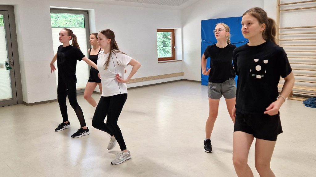 Jugendliche der Tanzgruppe „Mixtape“ bei einer synchronen Übung im KiTa-Bewegungsraum