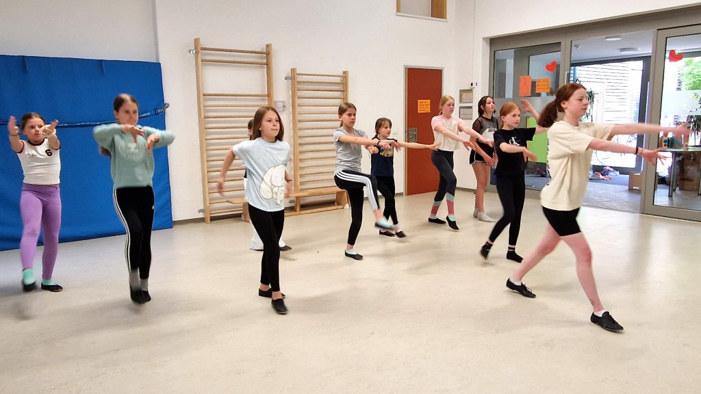 Mädchen der Tanzgruppe „Next Generation“ beim Choreografie-Training mit Schrittfolgen und Armbewegungen im KiTa-Bewegungsraum