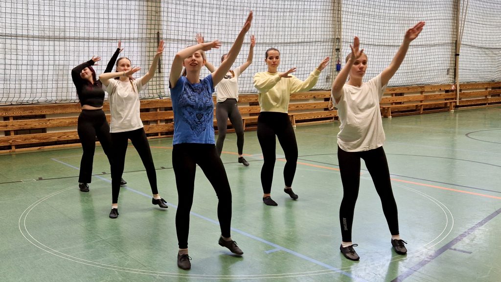 Junge Frauen der „Blond AG“ tanzen synchron in der Sporthalle