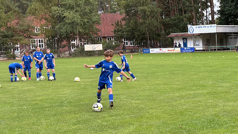 Kinder der D-Jugend mit Ball beim Techniktraining vor dem Vereinsheim