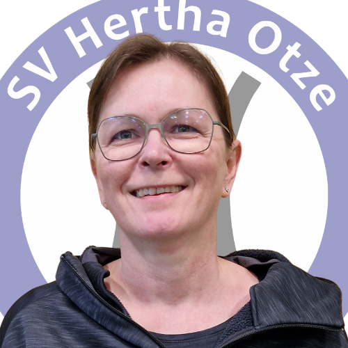 Portrait von Steffi Mierswa vor dem Logo des SV Hertha Otze. Sie trägt eine Brille, ein dunkles Oberteil mit Kapuze und lächelt freundlich in die Kamera.