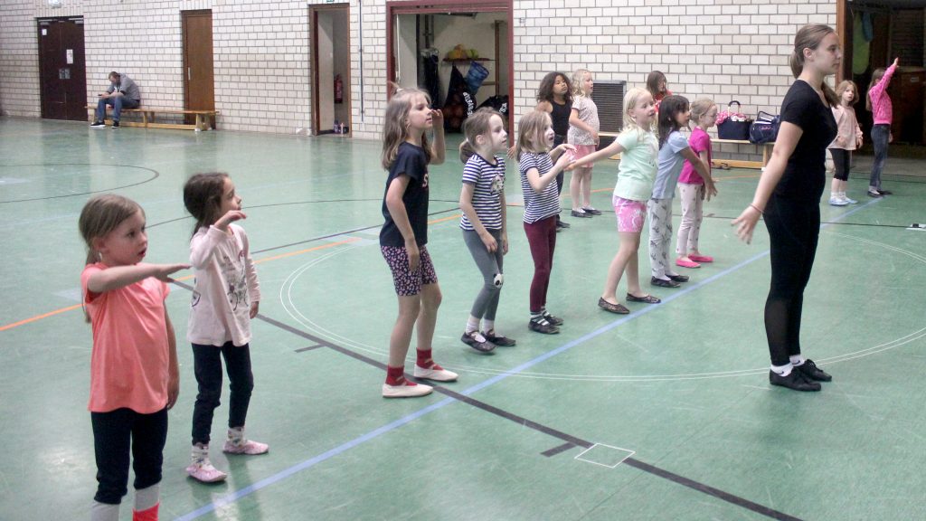 Kinder der Tanzgruppe „Sternchen“ tanzen in der Turnhalle unter Anleitung der Übungsleiterin